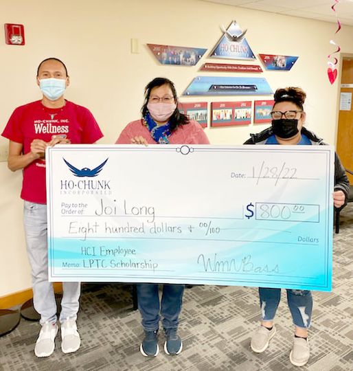Three individuals holding a check.